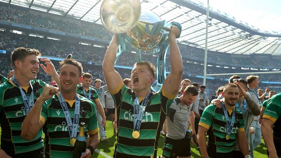 Fin Smith lifts the Gallagher Premiership trophy for Northampton Saints.