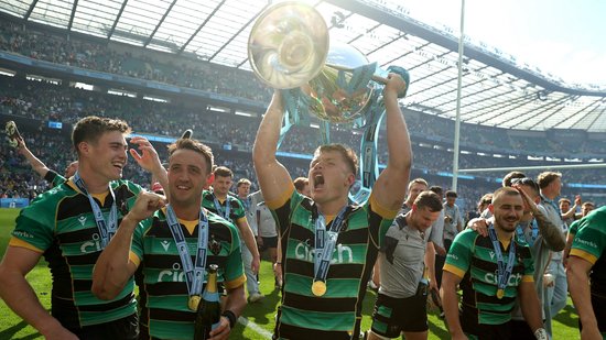 Fin Smith lifts the Gallagher Premiership trophy for Northampton Saints.